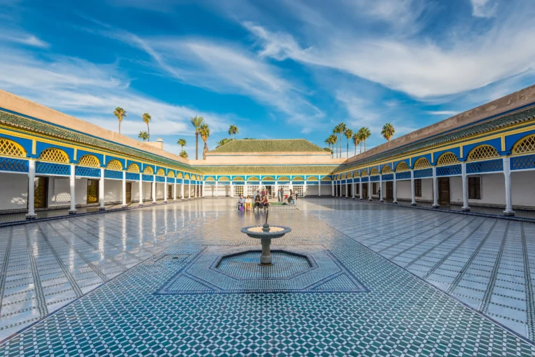 Large marble courtyard of the Bahia Palace with blue and yellow mosaics.