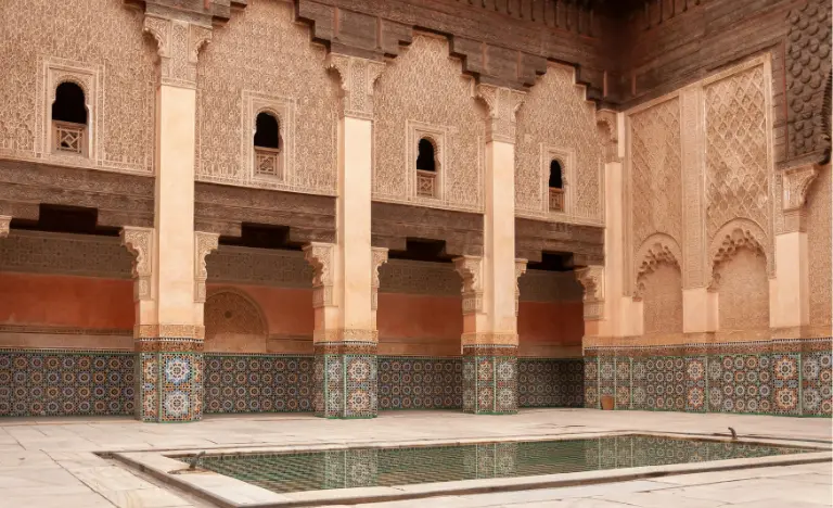 The ornate courtyard of Ben Youssef Medersa with a central reflection pool.