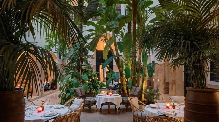 Table set for a romantic dinner in the flowery patio of a quiet, lush riad.