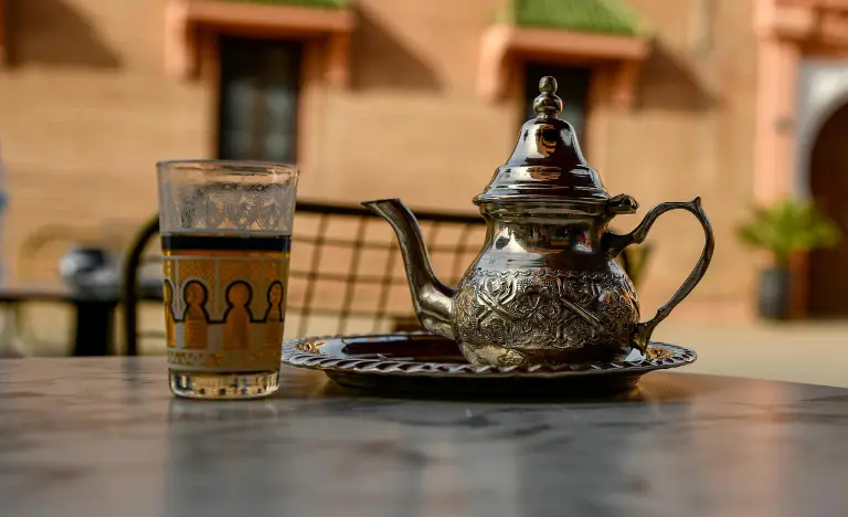 Traditional Moroccan mint tea served in a silver pot and patterned glass.