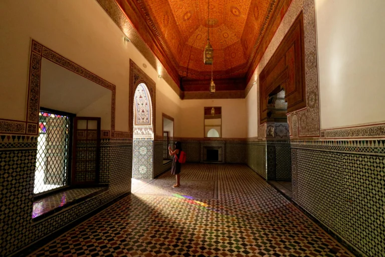 Sunlight streaming into a room with intricate zellij tilework and a cedar ceiling.