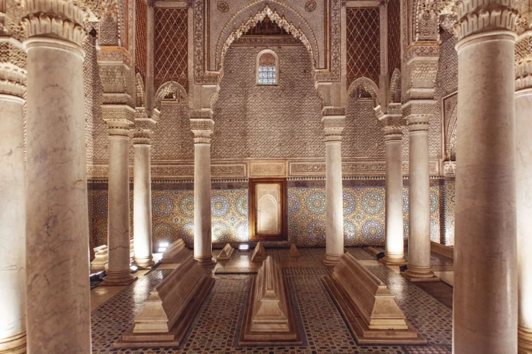 Intricate marble columns and geometric tiled walls inside a majestic burial chamber.