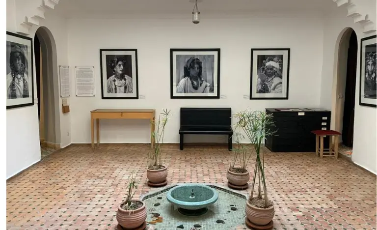 A bright courtyard gallery displaying portraits around a central mosaic fountain.