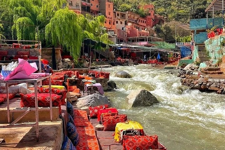 Beautiful landscape of the Ourika Valley with tables along the flowing river.