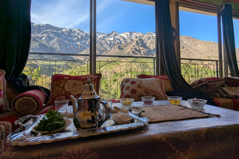 A dining area with a stunning view of snow-capped mountains and green valleys.
