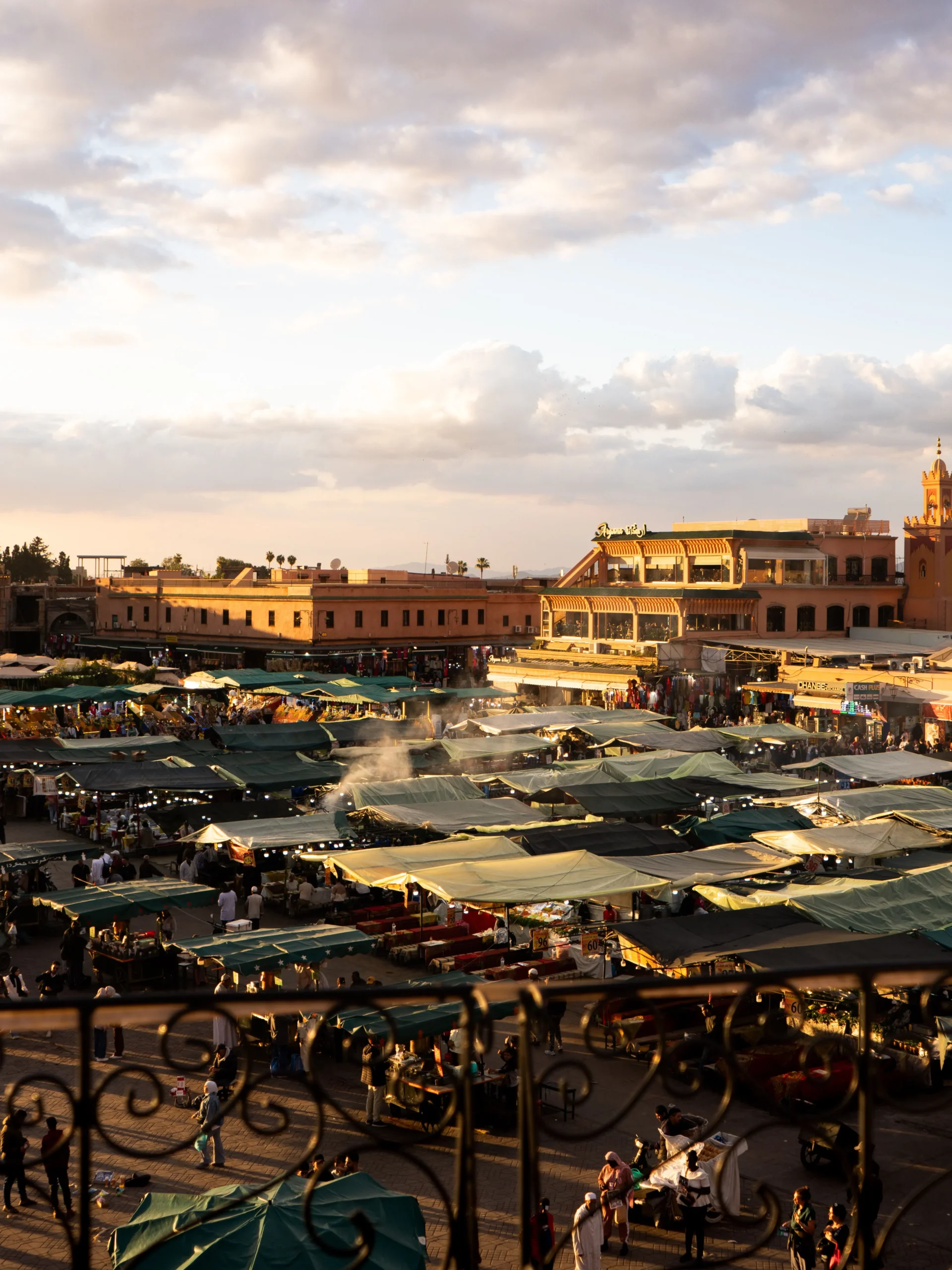 Jemaa el-Fna market stalls at sunset seen from a rooftop terrace, meeting point of the Marrakech shopping tour