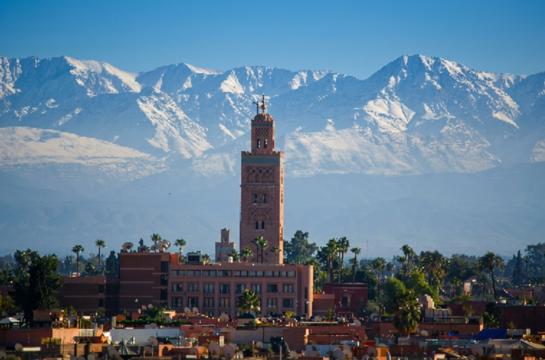 Koutoubia Mosque with the snowy Atlas Mountains, showing Marrakech weather in winter